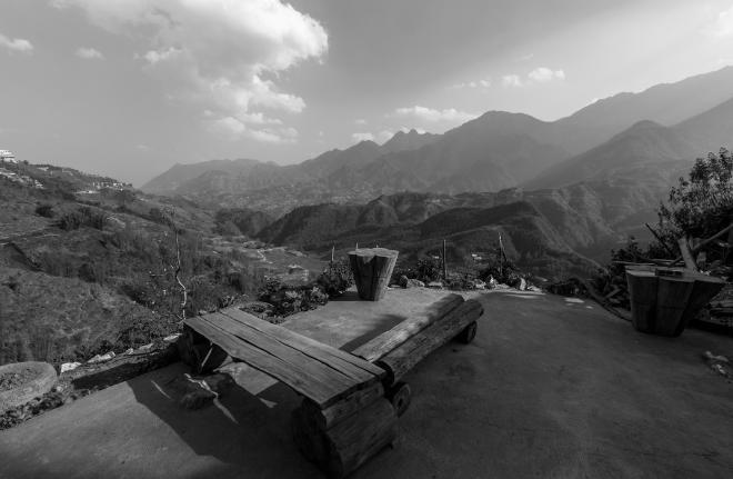 Wooden bench on a patio with a view of mountains in the background